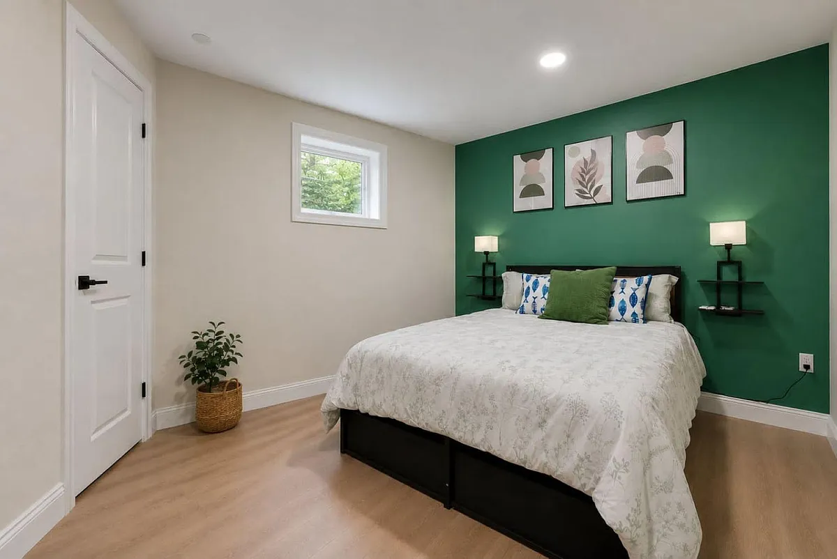Photo 2 of 7 - 12th Ave E - Bradenton, FL Well-appointed bedroom with a full bed, wall-mounted nightstands, and a window for natural light, plus closet access. - 12th Ave E
