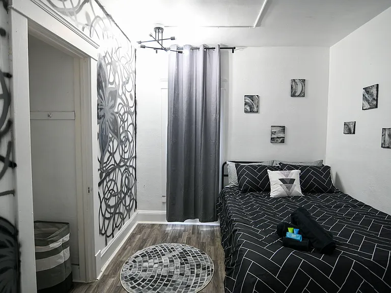Private bedroom with a full bed, window with curtains, and durable flooringideal for a simple, restful setup.