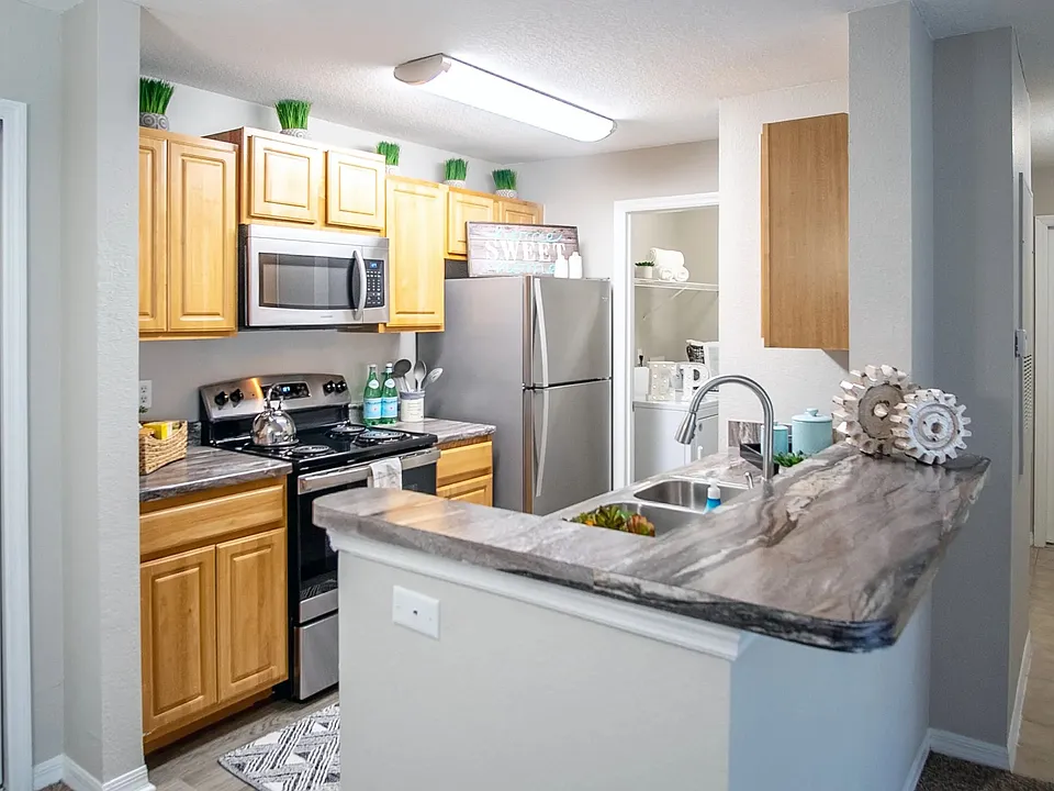 This thoughtfully designed kitchen combines style and functionality with ample storage, modern appliances, and a breakfast bar that overlooks the living space.