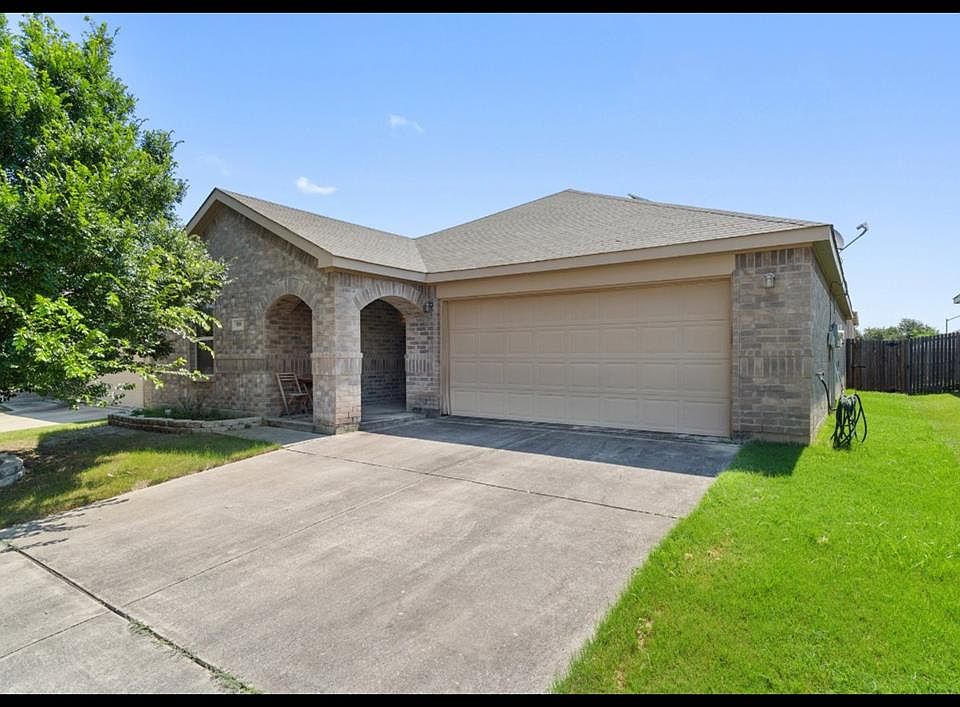 Ranch-style home with a front yard and a garage