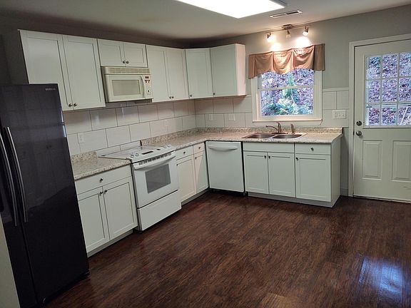 Kitchen with stainless steel fridge. Range, microwave, dishwasher. New counters, cabinets and tile backsplash installed 2019.