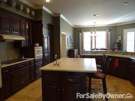 Custom kitchen with wilson art countertops, double oven and raised dishwasher