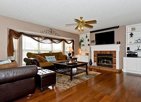 The family room is open and spacious with new hardwood floor and a wood burning fire place and custo
