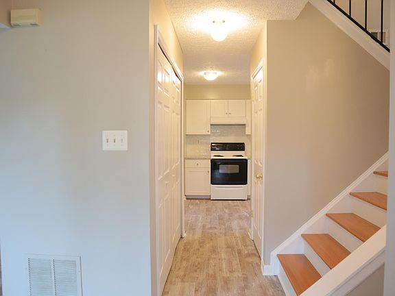 Front door opens to view of the kitchen; two utility closets on each side of the hallway. White kitchen cabinets and granite countertop were recently installed.