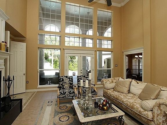 The living room has tile floors, an incredible "wall of windows" overlooking the gorgeous back yard pool/spa area with double doors, and a gas fireplace.  Multi-level ceilings make it feel even more spacious.