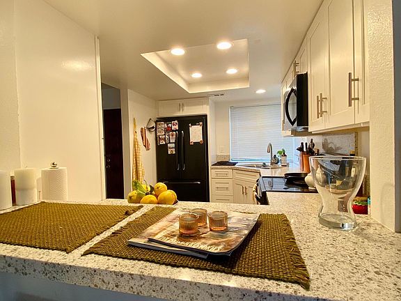 Bar area with quartz countertops facing into remodeled kitchen