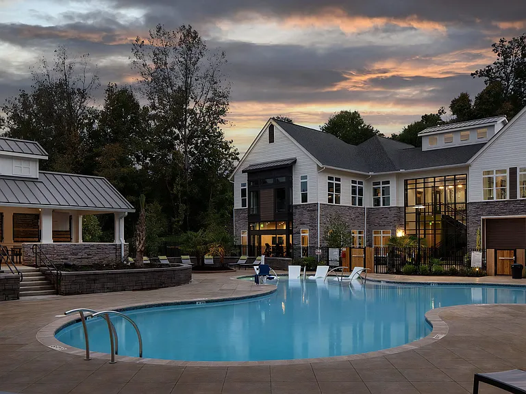 Evening Poolside Lounge with Clubhouse Backdrop and Landscaping
