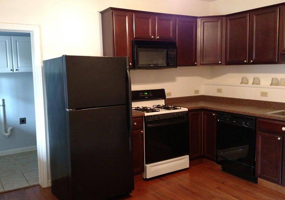 Kitchen and view into large bathroom. Washer / dryer hook up in bathroom. Gas stove. Dishwasher. Microwave. Frig. Ceiling fan not visible.