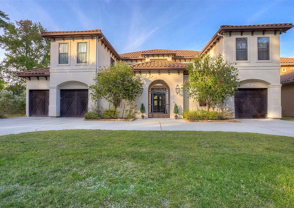 Magnificent Mediterranean custom lakefront home featuring an impressive circular driveway!