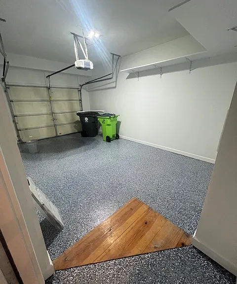 garage with epoxy floor for easy cleaning. wood shelves for storage