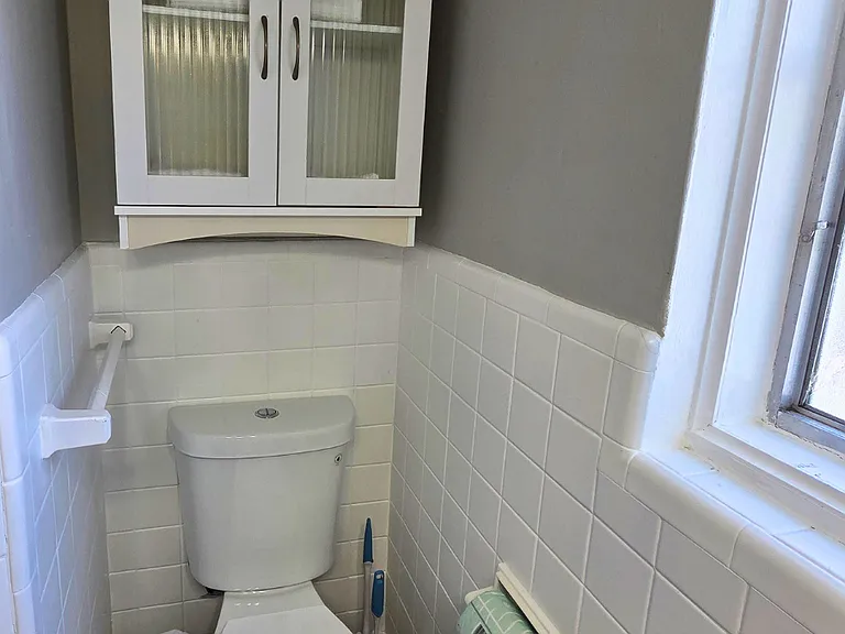 Functional bathroom with overhead cabinet and towel rack