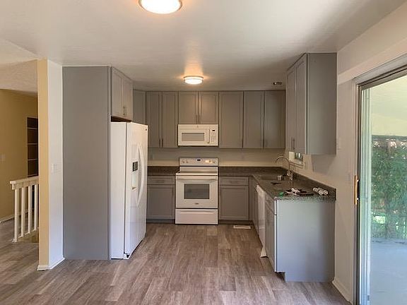 New kitchen view from man garage door entrance. All new soft close cabinets, countertop, paint, microwave, LVP floor, lights, disposal, electrical,etc.