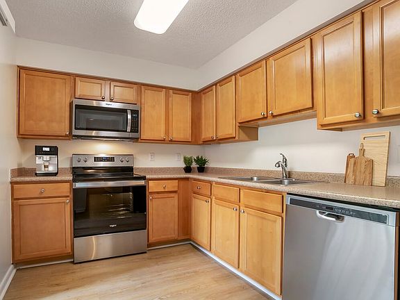 Upgraded Package I kitchen with oak cabinetry, beige laminate countertops, stainless steel appliances and hard surface flooring