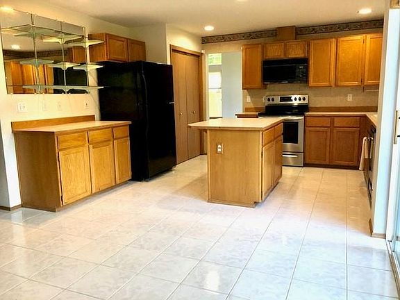Spacious kitchen with eating space and tile floor.