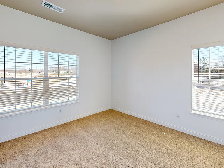 The Roth floor plan's bedroom provides ample natural light from large windows on two walls. The Roth floor plan's bedroom provides ample natural light from large windows on two walls.