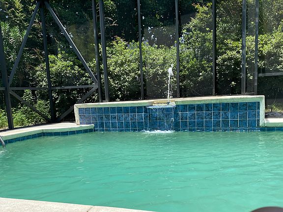 Pool with waterfall and jacuzzi tub on the left side