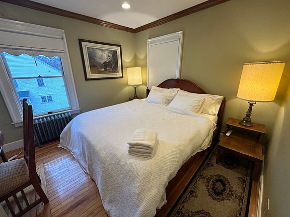 View from the entrance of the room, with the bed on the right, and two windows.