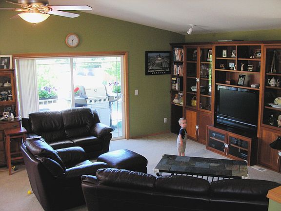 Half of great room with vaulted ceiling, opening to the upper patio.