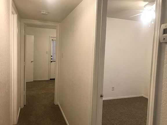 Hallway with view into master in rear and second bedroom on right