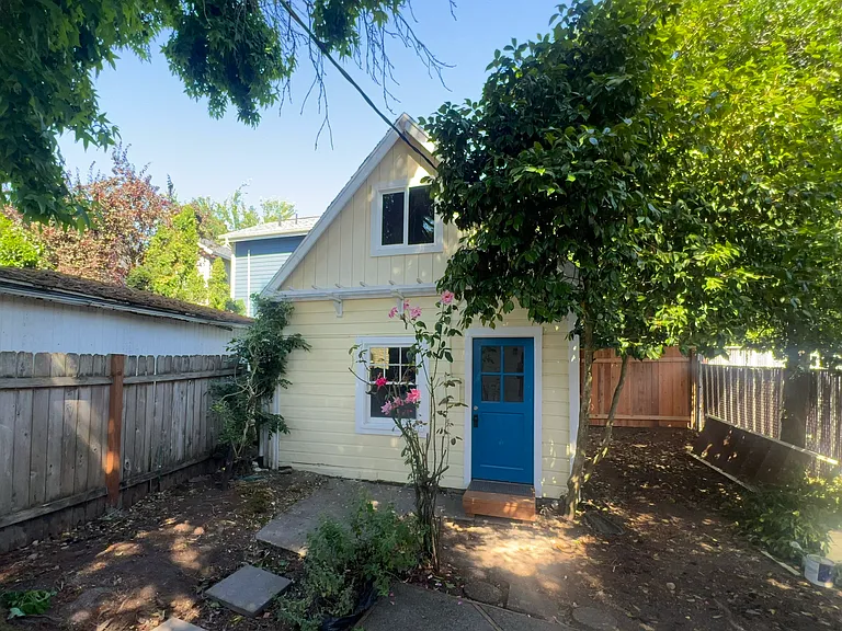Fully fenced backyard with deck, patio, and detached 200 sqft bedroom/office.