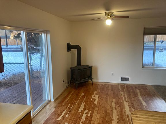 Dining room with hardwood floors, gas fireplace, ceiling fan, and cadet heating.