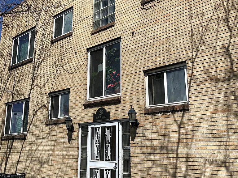 Charming brick apartment building with vintage architectural details and welcoming entrance, offering a cozy urban living experience.