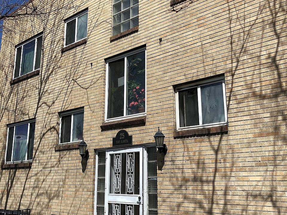 Charming brick apartment building with vintage architectural details and welcoming entrance, offering a cozy urban living experience.