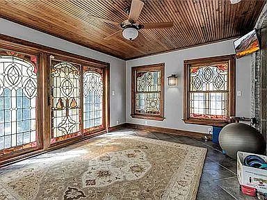 exercise room surrounded by stained glass windows and patio doors leading to an outside 2nd-floor balcony