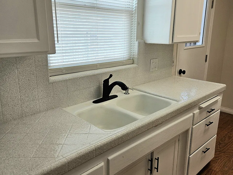 Double sink with trash compactor.