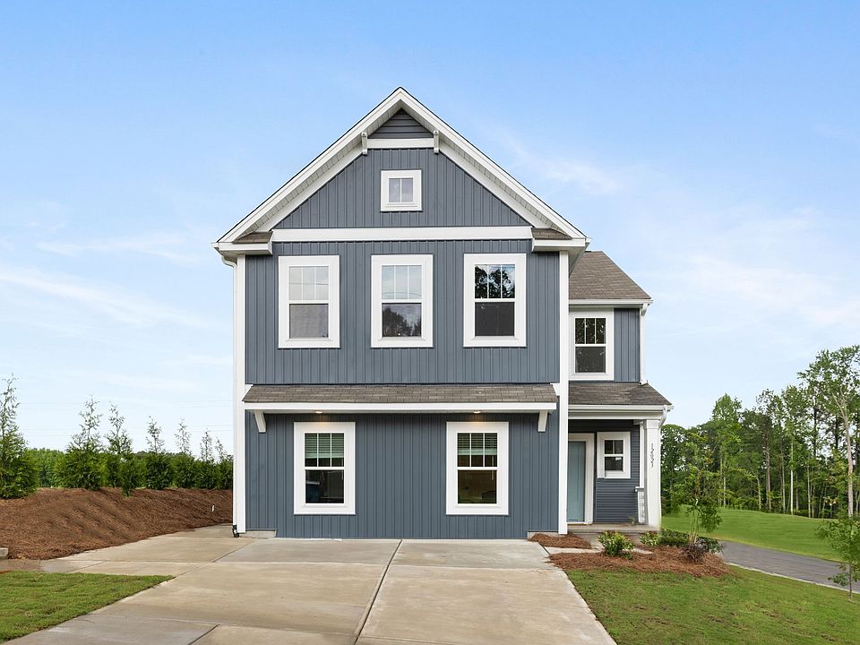 The front of a blue house with white trim and windows.