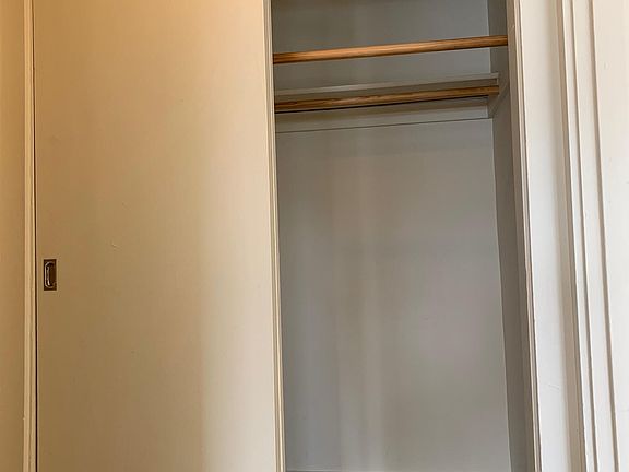 Large closet with 2 rods to hang clothes on located between the bedroom and the bathroom