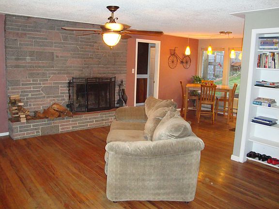 Open living/dining room with original hardwood floors and 2 fireplaces