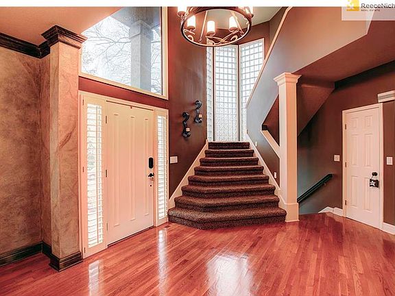 Dramatic two story entry with beautiful hardwood floors and a stunning light fixture.