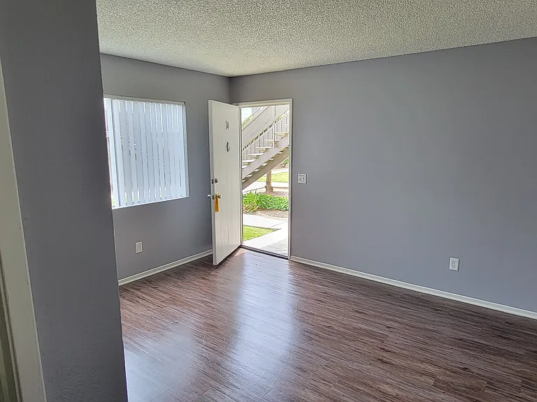 Front room with hardwood floors and lots of natural light at Grand Oaks Apartments in Lake Elsinore, California.