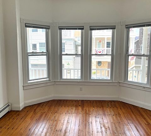 Spacious bedroom with high ceilings, beautiful hardwood floors