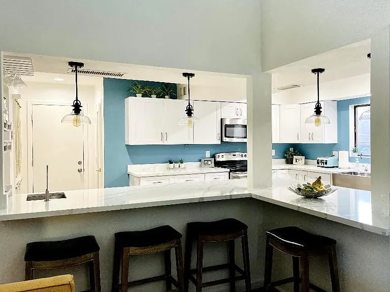 Kitchen view from living room. Door in back of photo is to the garage. Walk-in pantry to right of garage.