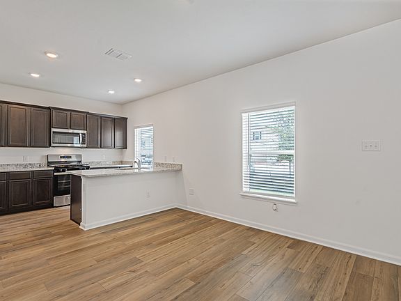 Open-concept layout with the upgraded kitchen overlooking the dining area.