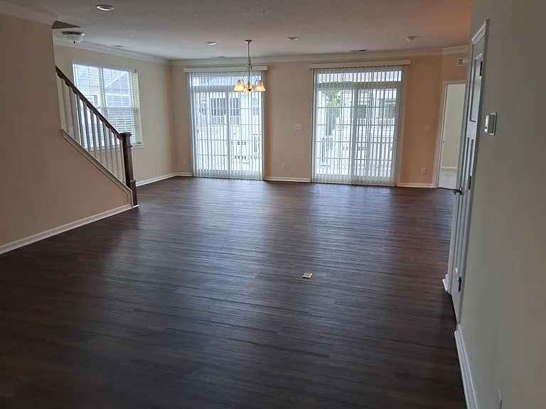 Living room and the staircase leading to the third floor. French doors leads to a sunny balcony.