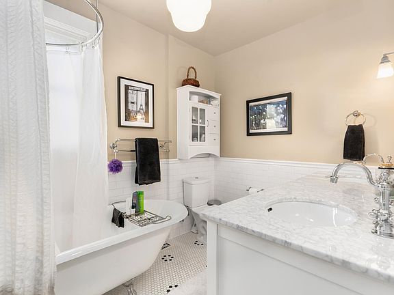 Bathroom, re-done with period details, pedestal tub, and double marble vanity.