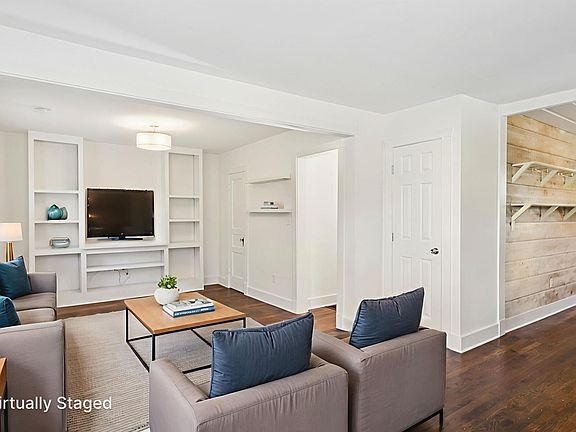 Virtually staged to show a comfortable living area with space for seating, a media center, and decor, perfect for entertaining.
