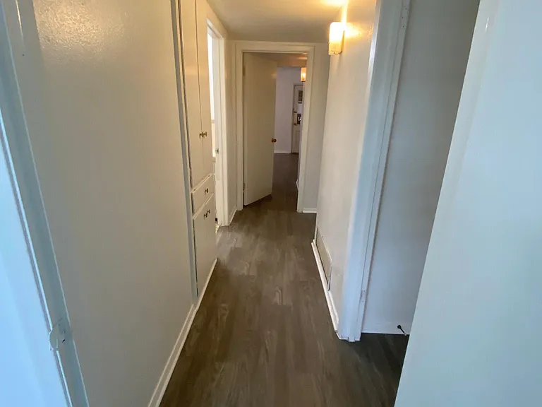 Hallway with built in cabinets and laundry shoot