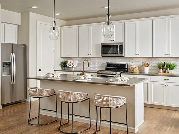 Kitchen with White Cabinetry and Pendant Lighting Over the Island