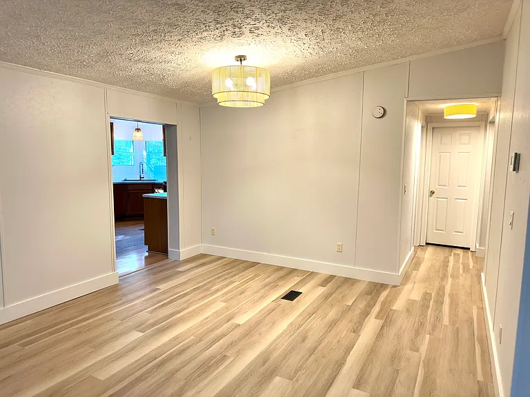 Dining area between kitchen and living area. New chandelier provides great light.