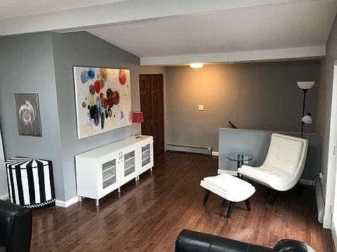 living room with leather chair and ottoman, hardwood floors
