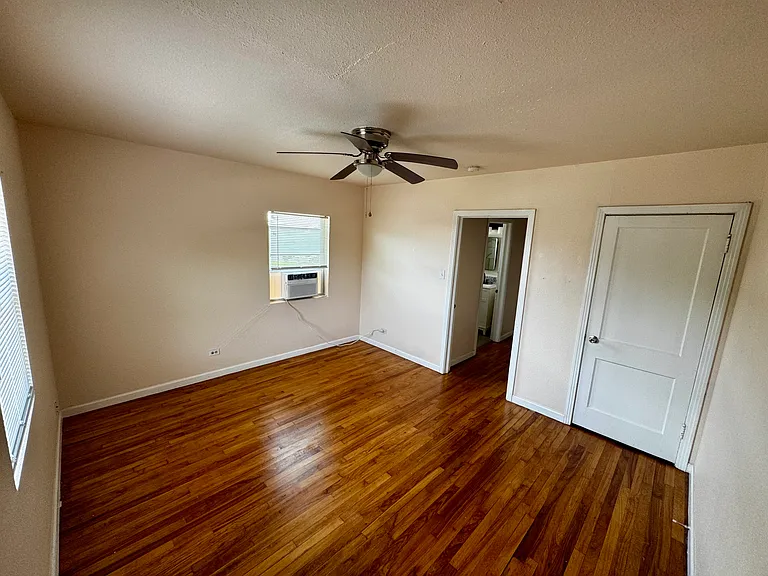 Spacious bedroom with beautiful hardwood floors and brand-new window unit