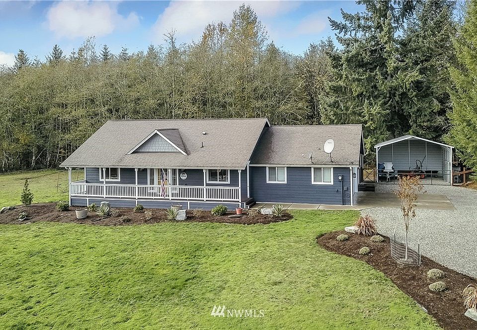 Front view of home, note the front covered porch, beautiful landscaping and carport! 