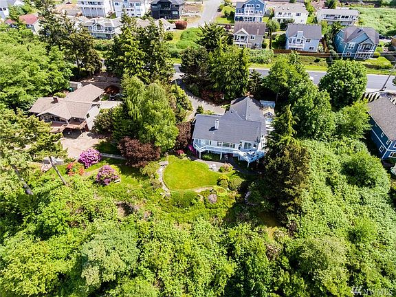 The home features generous guest parking along Oakes Ave with a gentle walkway down to the home.