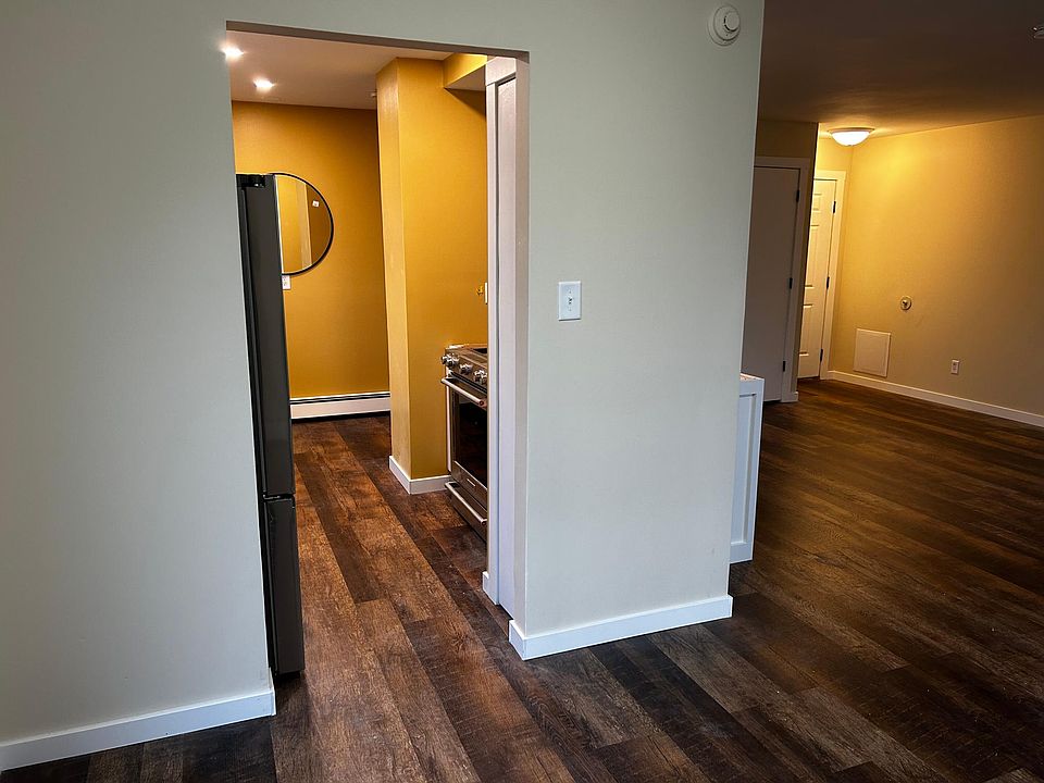 View from the dining area into the kitchen, coat closet, and front door.