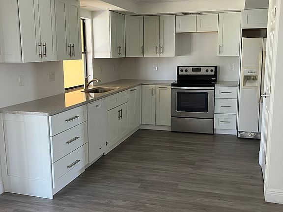 Open kitchen with modified raised ceiling. Lots of ceiling lights in kitchen and dining areas.