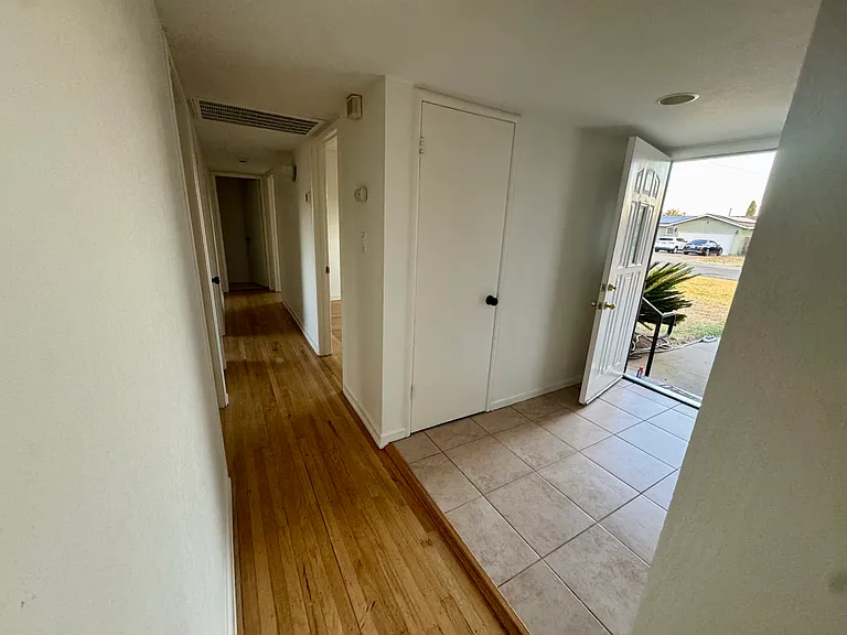 Entry way with coat closet and hallway to bedrooms and bathrooms